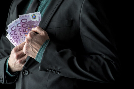 Businessman in business suit holding 500 euro bills near inside