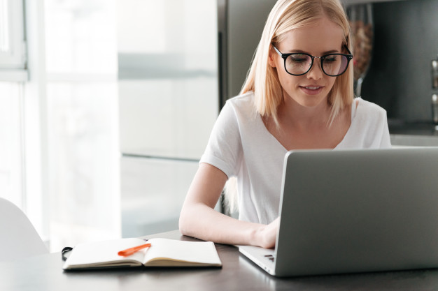concentrated-young-lady-working-with-laptop-home_171337-4898