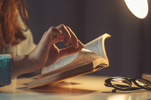 woman-reading-book-evening-home-close-up_122732-1098