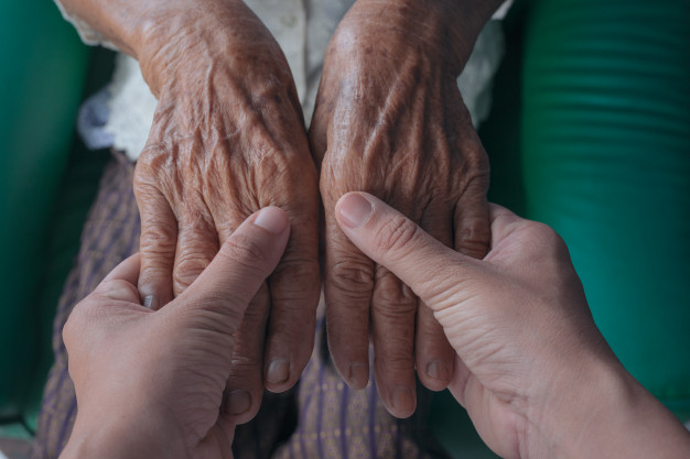 young-woman-holding-elderly-woman-s-hand_1150-12496