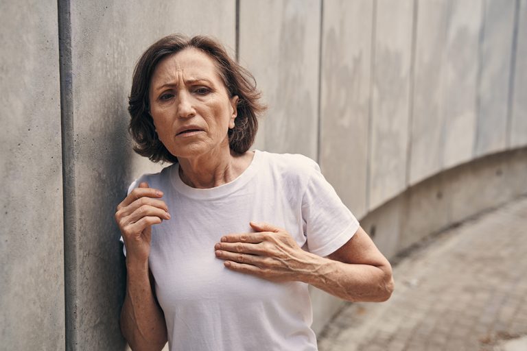 Active aged woman having heart attack outdoors