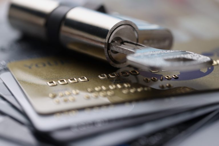 lock-with-key-rests-on-plastic-credit-cards