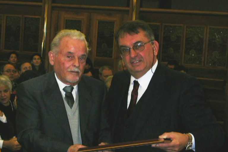2002 – GioBatta Rossi riceve una targa dal presid. CMA Rizieri Ongaro per gli 80 anni e per il contributo dato in campo linguistico ed etnografico