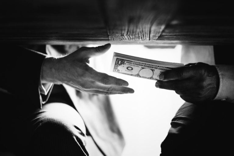 hands-passing-money-under-the-table-corruption-and-bribery