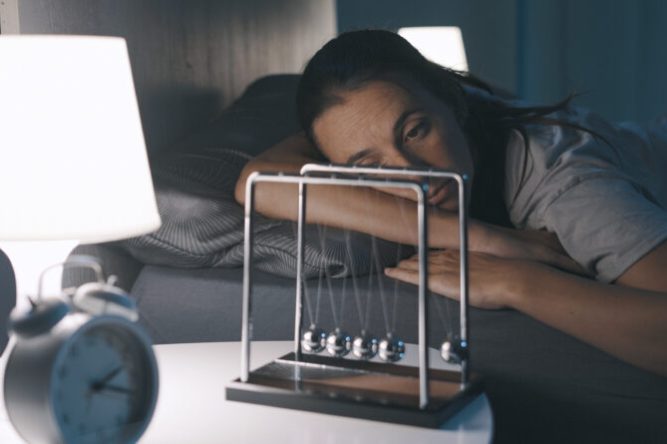 Sad woman suffering from insomnia in her bed