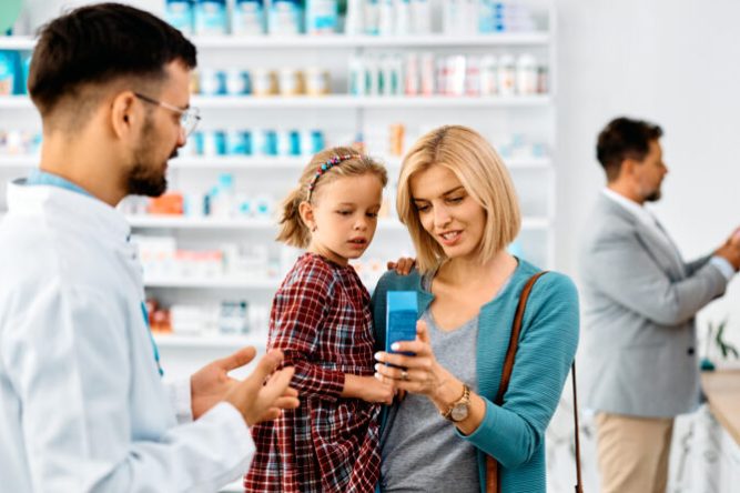Happy mother with daughter buying in a pharmacy,