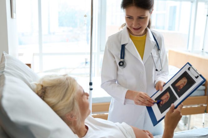 Nurse with ultrasound photo and pregnant woman looking at each other